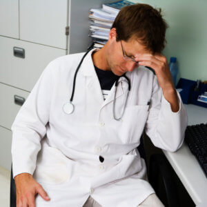 Male Doctor in white lab coat, looking disheveled and upset