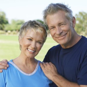 Older couple smiling and enjoying retirement, safely. 