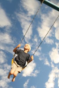 Small child swinging on a chain swing set