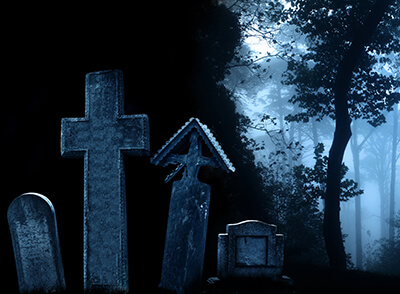 Medieval stone crosses and tombstones, cemetery in misty forest
