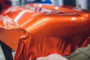 Vinyl wrap being applied to a motorcycle part