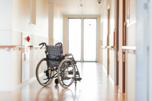 Wheelchair in the middle of a brightly lit nursing home hallway