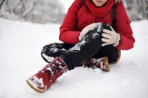 personal injury lawyer slip and fall - person in the snow - knee injured