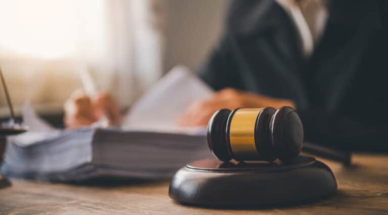Gavel and legal documents sitting on wooden office desk next to judge